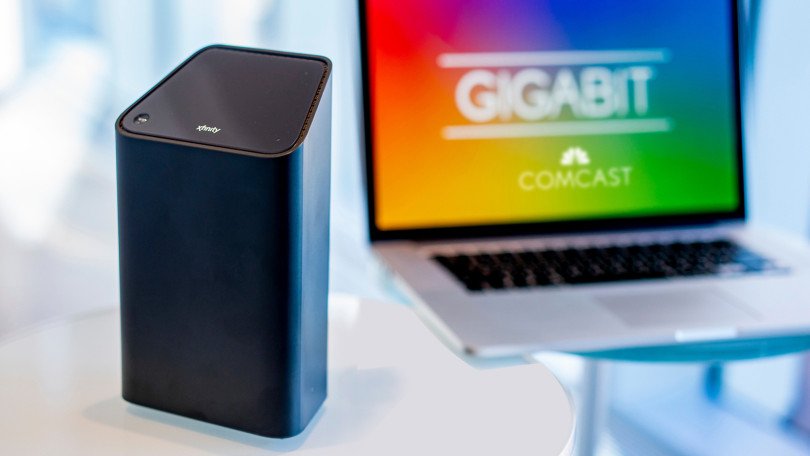An Xfinity Gateway device and a laptop displaying the Comcast logo.